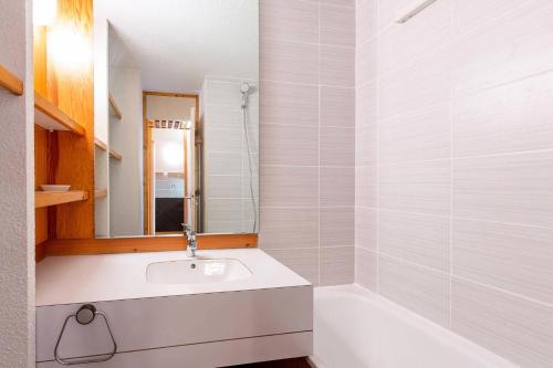 une salle de bain blanche avec un lavabo et une baignoire dans l'établissement Résidence Le Zig Zag - ZIG ZAG 01 MAE-0391, à La Plagne Tarentaise