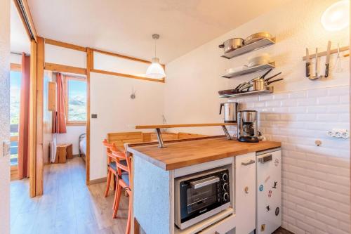 une cuisine avec un comptoir et un plan de travail dans l'établissement Résidence Le Trompe L'oeil - TROMPE L’ŒIL 09 MAE-0421, à La Plagne Tarentaise