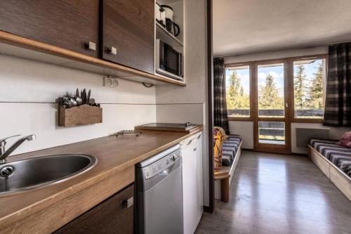 une cuisine avec un évier et un plan de travail dans l'établissement Résidence Le Bilboquet - Studio pour 4 personnes de 24m² MAE-0461, à La Plagne Tarentaise