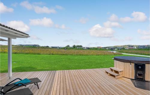 a wooden deck with a grill and a bench on it at Lovely Home In Løkken With Sauna in Løkken