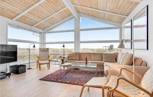 a living room with a couch and a table at 5 Bedroom Stunning Home In Blokhus in Blokhus