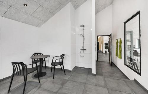 a dining room with a table and chairs and a mirror at Nice Home In Blåvand With Kitchen in Blåvand