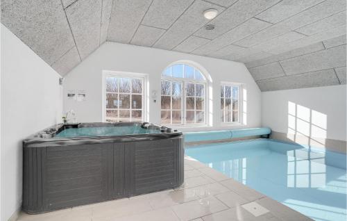 a large bathroom with a large tub in the middle at 7 Bedroom Gorgeous Home In Ulfborg in Øby