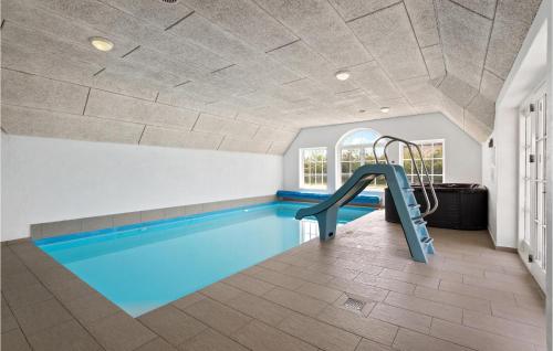 a swimming pool with a slide in the middle of a room at Pet Friendly Home In Ulfborg in Ulfborg