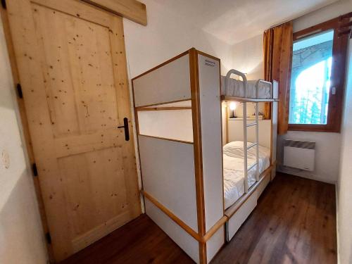Cette petite chambre dispose d'un réfrigérateur et d'une porte. dans l'établissement Résidence L'epervier - Appartement 2 pièces pour 6 personnes de 47m² MAE-0571, à La Plagne Tarentaise