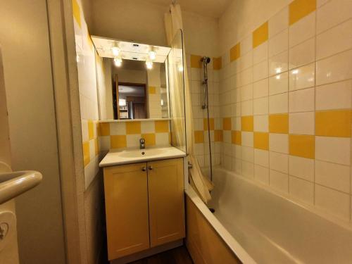 une salle de bain avec un lavabo, une baignoire et un miroir dans l'établissement Résidence L'epervier - Appartement 2 pièces pour 6 personnes de 47m² MAE-0571, à La Plagne Tarentaise