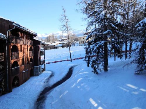 une rue enneigée avec une maison et des arbres dans l'établissement Résidence Les Pentes - PENTES 10 MAE-0581, à La Plagne Tarentaise