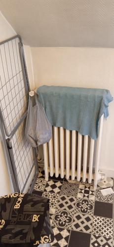 une chambre avec un radiateur et une couverture au sol dans l'établissement Tour du Roi du Mans !, au Mans