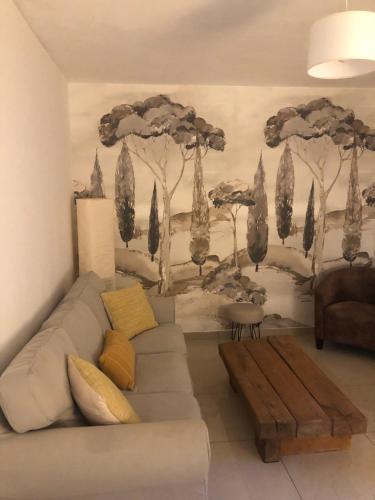 a living room with a couch and a wall with trees at Apartment Olive & Kin, Collioure in Collioure