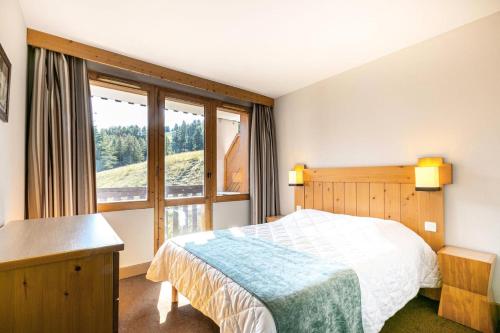 une chambre avec un lit et une grande fenêtre dans l'établissement Résidence La Marelle - Appartement 2 pièces pour 5 personnes de 36m² MAE-0641, à La Plagne Tarentaise