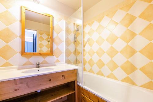 une salle de bain avec un lavabo, une baignoire et un miroir dans l'établissement Résidence La Marelle - Appartement 2 pièces pour 5 personnes de 36m² MAE-0641, à La Plagne Tarentaise