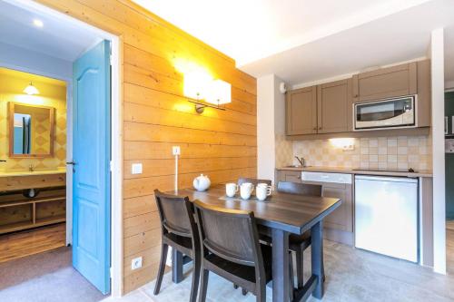 une cuisine avec une table et des chaises dans une pièce dans l'établissement Résidence La Marelle - Appartement 2 pièces pour 5 personnes de 36m² MAE-0641, à La Plagne Tarentaise
