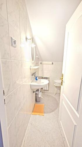 a white bathroom with a sink and a shower at VILLA MEDICA - Ośrodek wypoczynkowy z basenem oraz pełnym wyżywieniem in Rabka