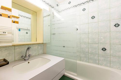La salle de bains blanche est pourvue d'un lavabo et d'une baignoire. dans l'établissement Résidence La Clef - Studio divisible pour 4 personnes de 24m MAE-0671, à La Plagne Tarentaise