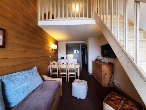 un salon avec un canapé et un escalier dans l'établissement Résidence La Marelle - MARELLE 517 MAE-0721, à La Plagne Tarentaise