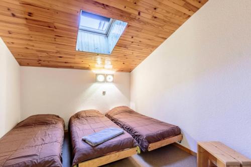 deux lits dans une chambre avec un plafond en bois dans l'établissement Résidence Le Trompe L'oeil - TROMPE L'OEIL 25 MAE-0771, à La Plagne Tarentaise