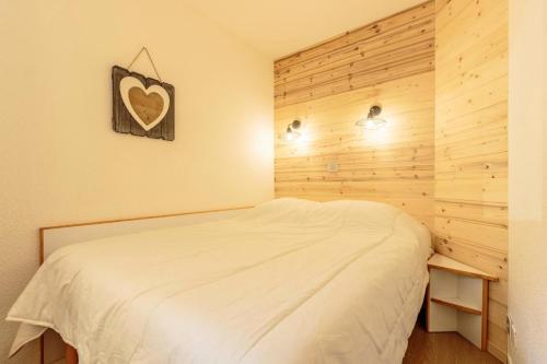 une chambre avec un lit blanc et un mur en bois dans l'établissement Résidence Le Sextant - SEXTANT 306 MAE-0781, à La Plagne Tarentaise