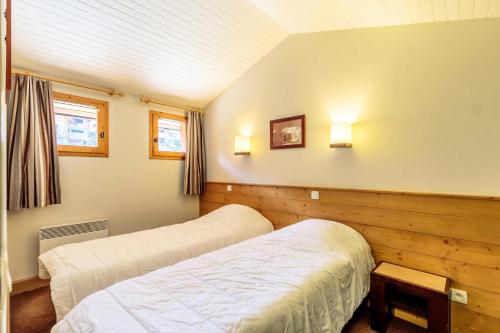 - une chambre avec deux lits et deux lumières sur le mur dans l'établissement Résidence La Marelle - Appartement 2 pièces pour 4 personnes de 35m² MAE-0791, à La Plagne Tarentaise