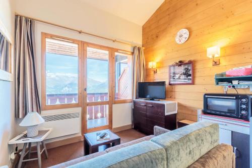 un salon avec un canapé et une télévision dans l'établissement Résidence La Marelle - Appartement 2 pièces pour 4 personnes de 35m² MAE-0791, à La Plagne Tarentaise