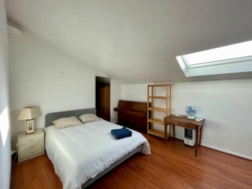 une chambre avec un lit, un bureau et une fenêtre dans l'établissement Appartement avec balcon vue sur le port & piscine, à Capbreton