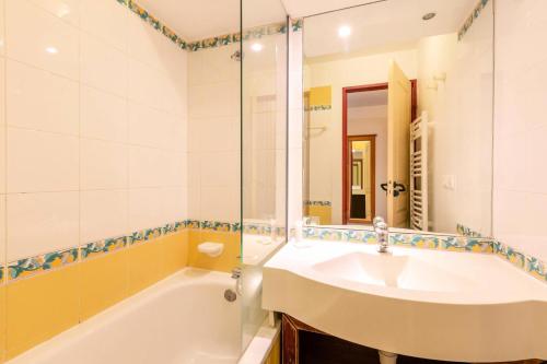 une salle de bain avec un lavabo, une baignoire et un miroir dans l'établissement Résidence Le Rami - RAMI 309 MAE-0821, à La Plagne Tarentaise
