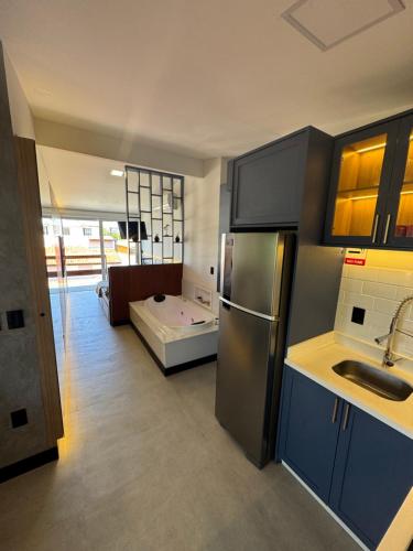 a kitchen with a sink and a refrigerator at Pousada Ilha do Campeche in Florianópolis