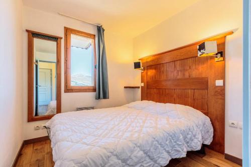 une chambre avec un grand lit et un miroir dans l'établissement Résidence Le Rami - RAMI 315 MAE-0851, à La Plagne Tarentaise