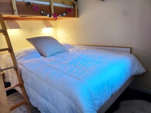 a bed with a blue comforter in a bedroom at Résidence Le Sextant - SEXTANT 304 MAE-0871 in La Plagne Tarentaise