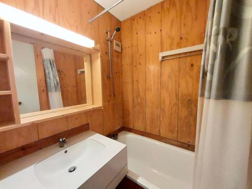 une salle de bain avec une baignoire, un lavabo et un miroir dans l'établissement Résidence Le Trompe L'oeil - TROMPE L'OEIL 46 MAE-0881, à La Plagne Tarentaise