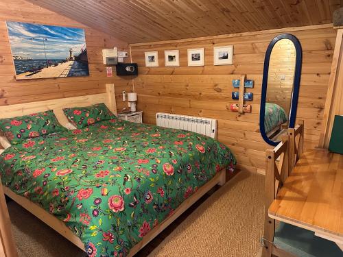 a bedroom with a bed in a wooden room at Cosy Cabin, hidden from the main house - Sleeps 2 - EV in Hawkinge
