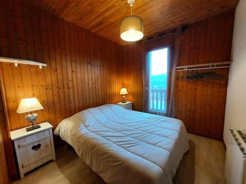 une chambre avec un grand lit et une fenêtre dans l'établissement Résidence Les Belles Feuilles - Appartement 2 pièces pour 6 personnes de 38m² MAE-0951, à La Plagne Tarentaise