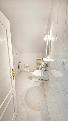 a white bathroom with a sink and a mirror at VILLA MEDICA - Ośrodek wypoczynkowy z basenem oraz pełnym wyżywieniem in Rabka