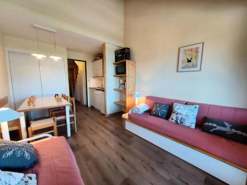 un salon avec un canapé rouge et une table dans l'établissement Résidence Le De 4 - Appartement 2 pièces pour 6 personnes de 35m² MAE-0941, à La Plagne Tarentaise