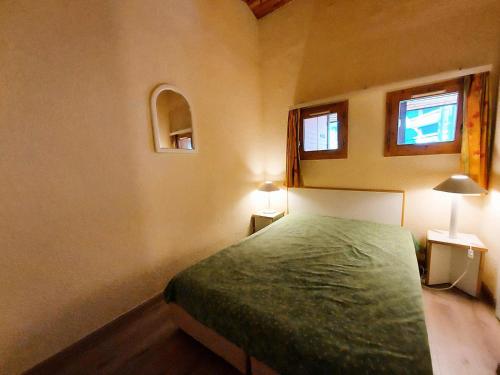 - une chambre avec un lit vert et 2 fenêtres dans l'établissement Résidence Le De 4 - Appartement 2 pièces pour 6 personnes de 35m² MAE-0941, à La Plagne Tarentaise