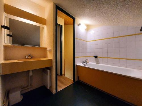 une salle de bain avec une baignoire, un lavabo et un miroir dans l'établissement Résidence Le De 4 - Appartement 2 pièces pour 6 personnes de 35m² MAE-0941, à La Plagne Tarentaise