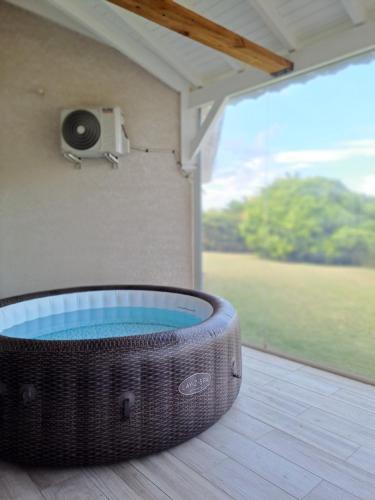 a hot tub in a room with a camera on the wall at Villa paisible in Goyave