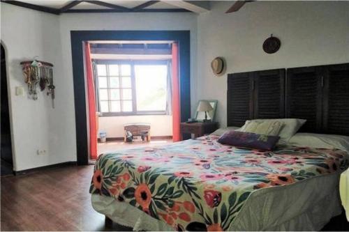 Un dormitorio con una cama con colcha floral y una ventana. en Espectacular casa en Olivos, en Olivos