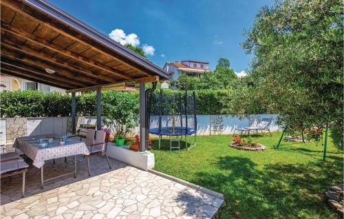 a backyard with a table and a swing at Amazing Home In Kostrena in Kostrena