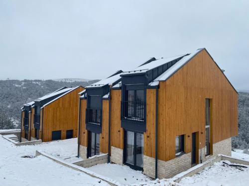 a row of houses in the snow at Tornik view villa Zlatibor 2 in Ribnica