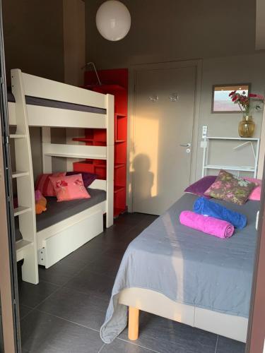 a bedroom with two bunk beds with purple and pink pillows at Villa Libecciu in Sainte-Lucie de Porto-Vecchio