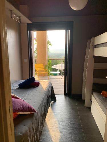 a bedroom with a bunk bed and a balcony at Villa Libecciu in Sainte-Lucie de Porto-Vecchio