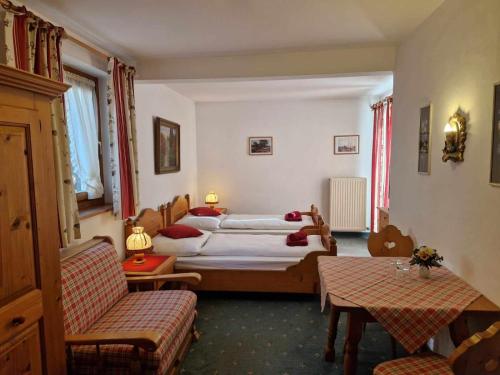 a hotel room with two beds and two chairs at Pension Alpenrose in Kitzbühel