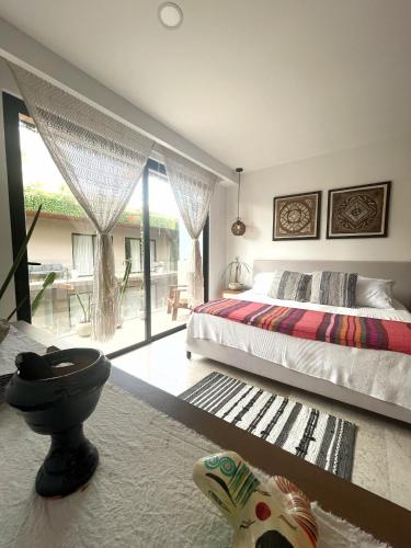 a bedroom with a bed and a large window at Estudio Asteroide in Tulum