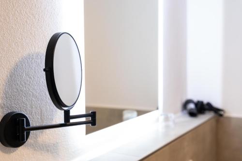 a mirror on a wall next to a sink at dreamcation Altstadthotel Regensburg, Mikro Apartments mit Küche in Regensburg