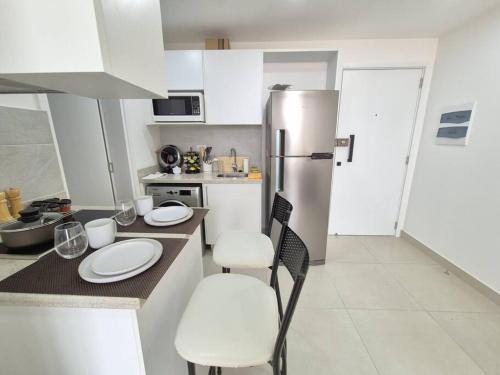 a kitchen with white cabinets and a refrigerator at Apartamento con pileta en Asunción centro in Asuncion