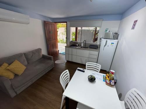 a kitchen and living room with a table and a couch at Pousada Ilha do Campeche in Florianópolis