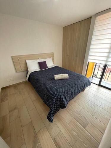 a bedroom with a bed with a black comforter at Departamento cerca Palacio Deportes, Estadio GNP, Aeropuerto AICM, Autódromo in Mexico City
