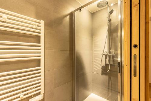 une douche avec une porte vitrée dans une salle de bain dans l'établissement Résidence Le Ridge - RIDGE 106 MAE-2431, à Arc 1600