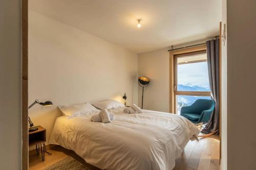 une chambre avec un lit, une fenêtre et une chaise dans l'établissement Résidence Le Ridge - RIDGE 106 MAE-2431, à Arc 1600