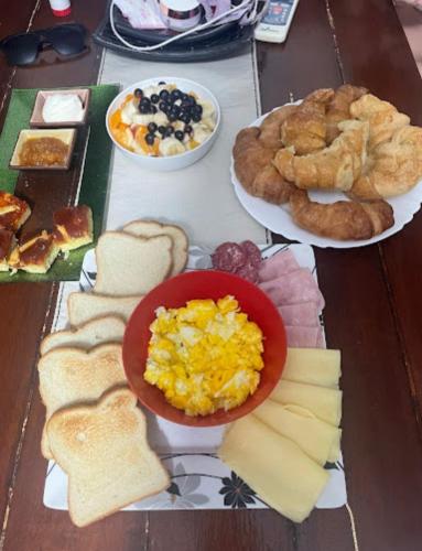 een tafel met borden ontbijtproducten en brood bij Alquimia in Villa Elisa